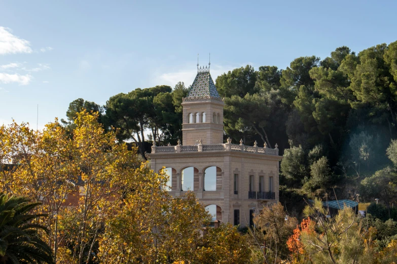 a building with a spire in the middle of trees