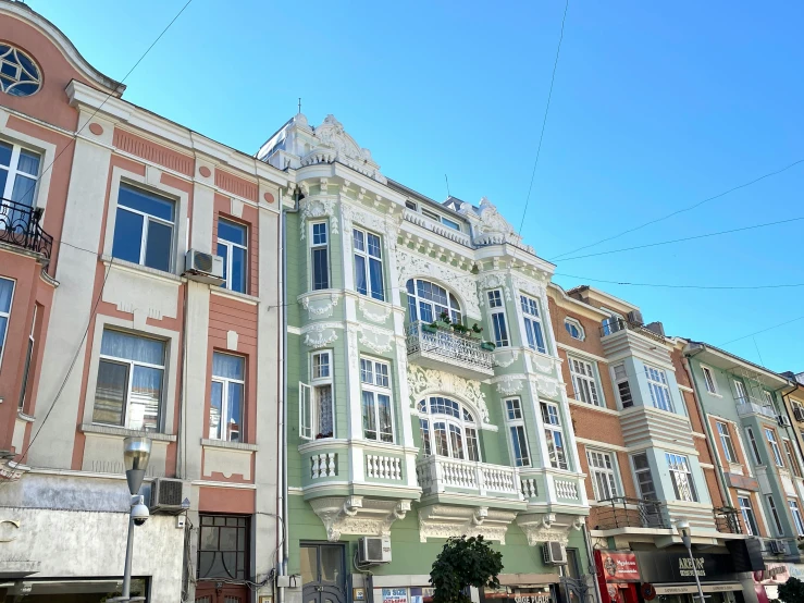 a tall building with windows and balconies against the blue sky