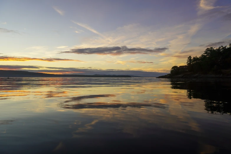 the sun is setting over a large body of water