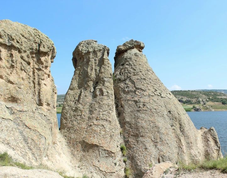 a large, tall rock formation near the water