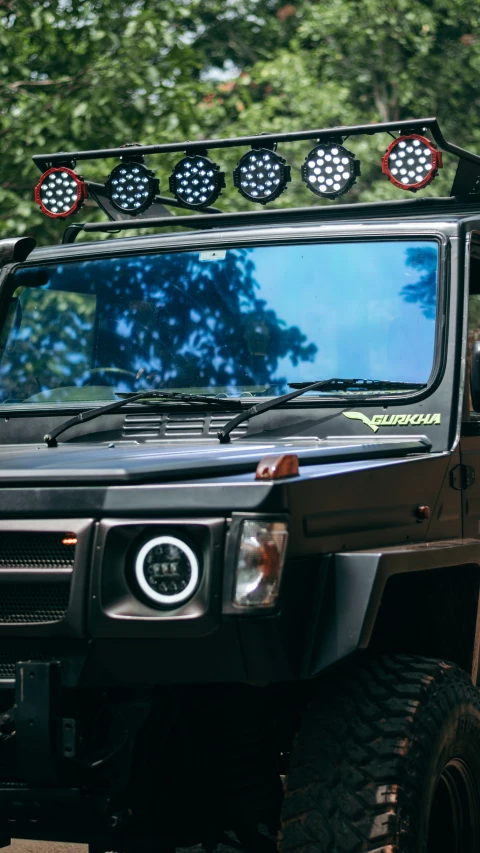 a black jeep with its headlights on in the park