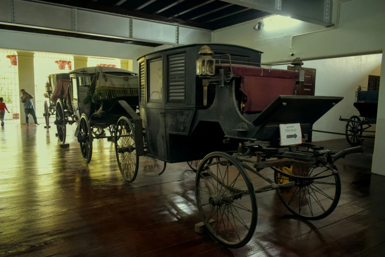 an old time carriage and other carriages displayed in a museum