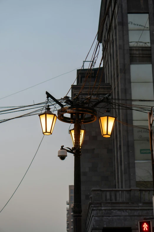 a building on a street corner, with street lamps and some wires