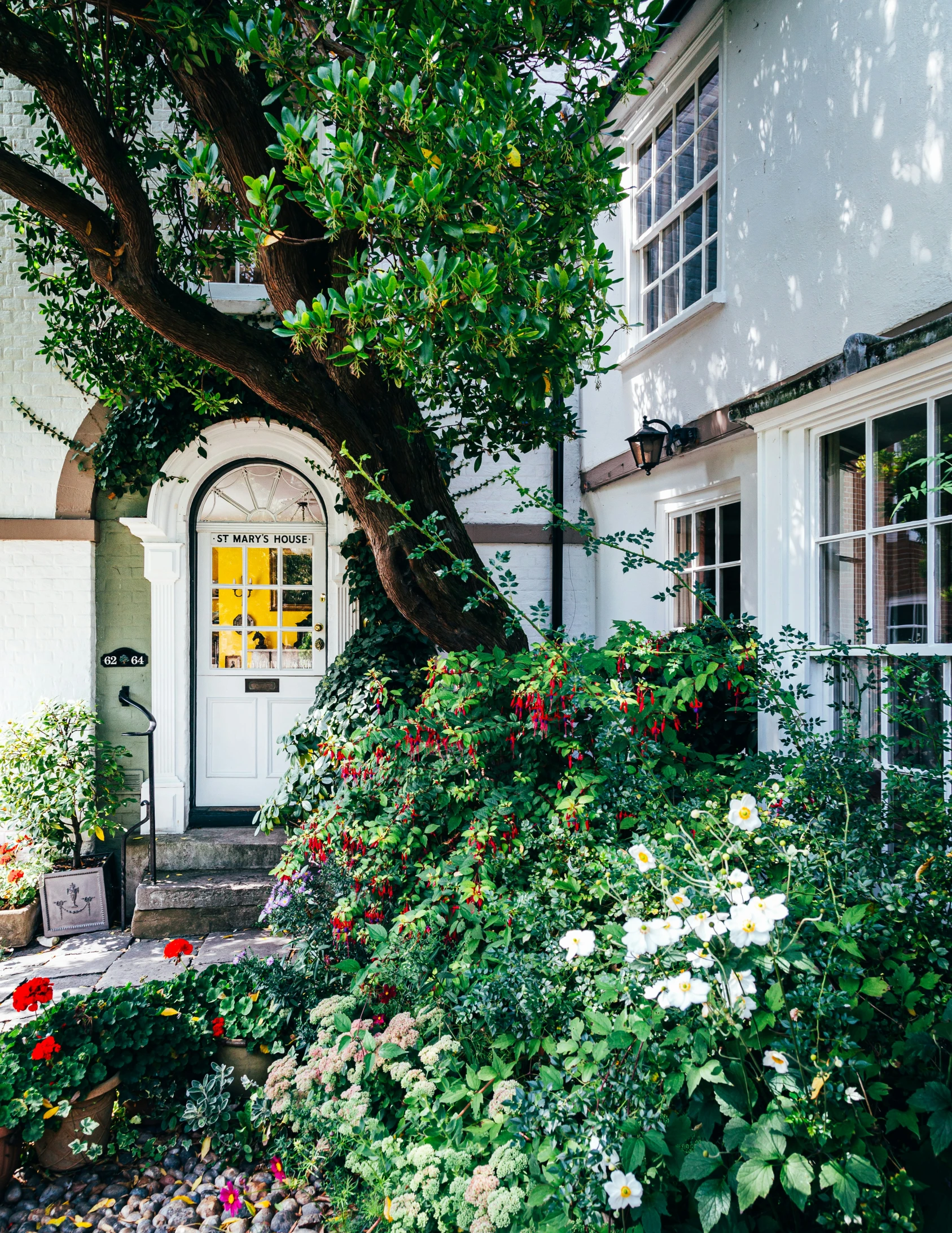 a house with a lot of flowers in front of it