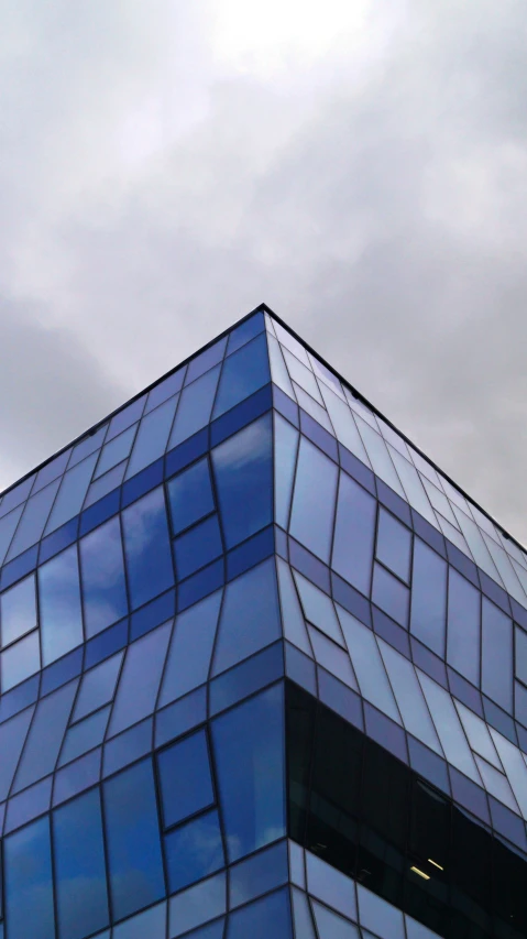 a glass building with the top part of the roof tilted to the ground