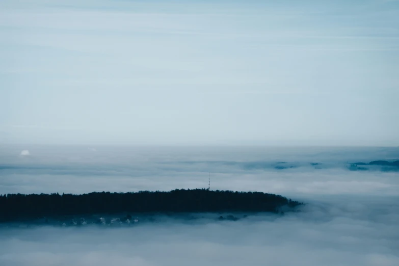 a very large tower on a hill covered in fog