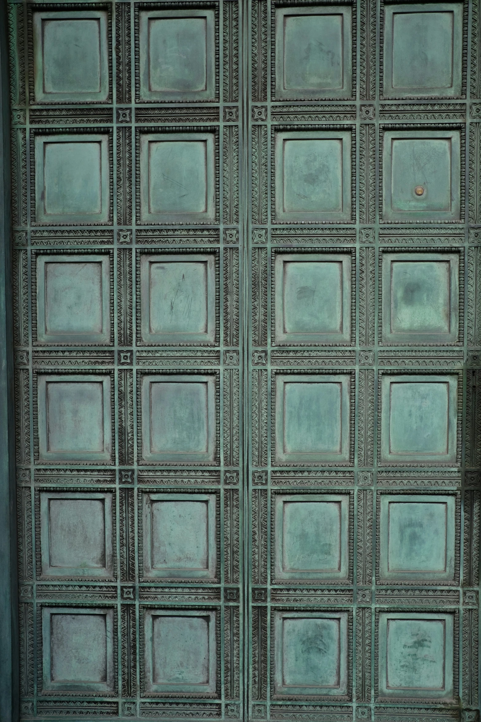 two animals grazing in front of a large metal door