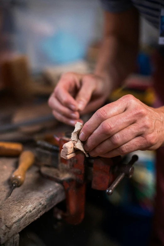 the person is working with a small piece of wood