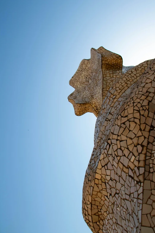 a brown bear statue with a sky background