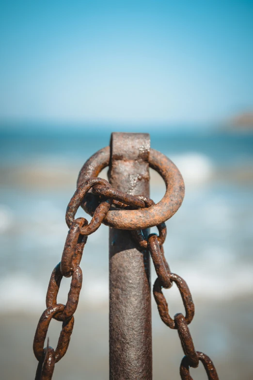 a rusty chain is on top of a pole