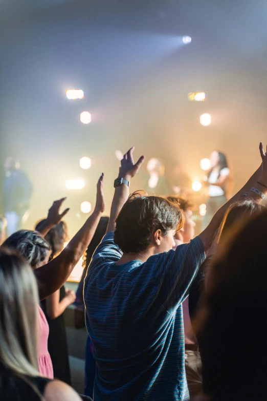 many people are standing and clapping at an event