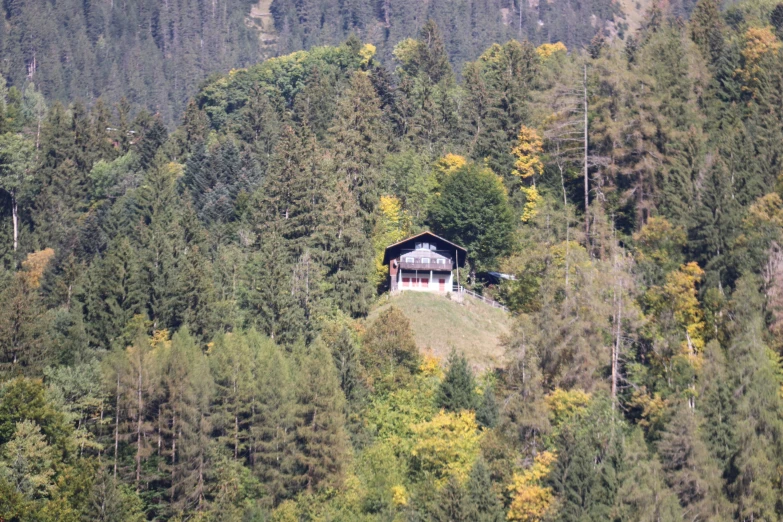 a view of some hills with trees and a building