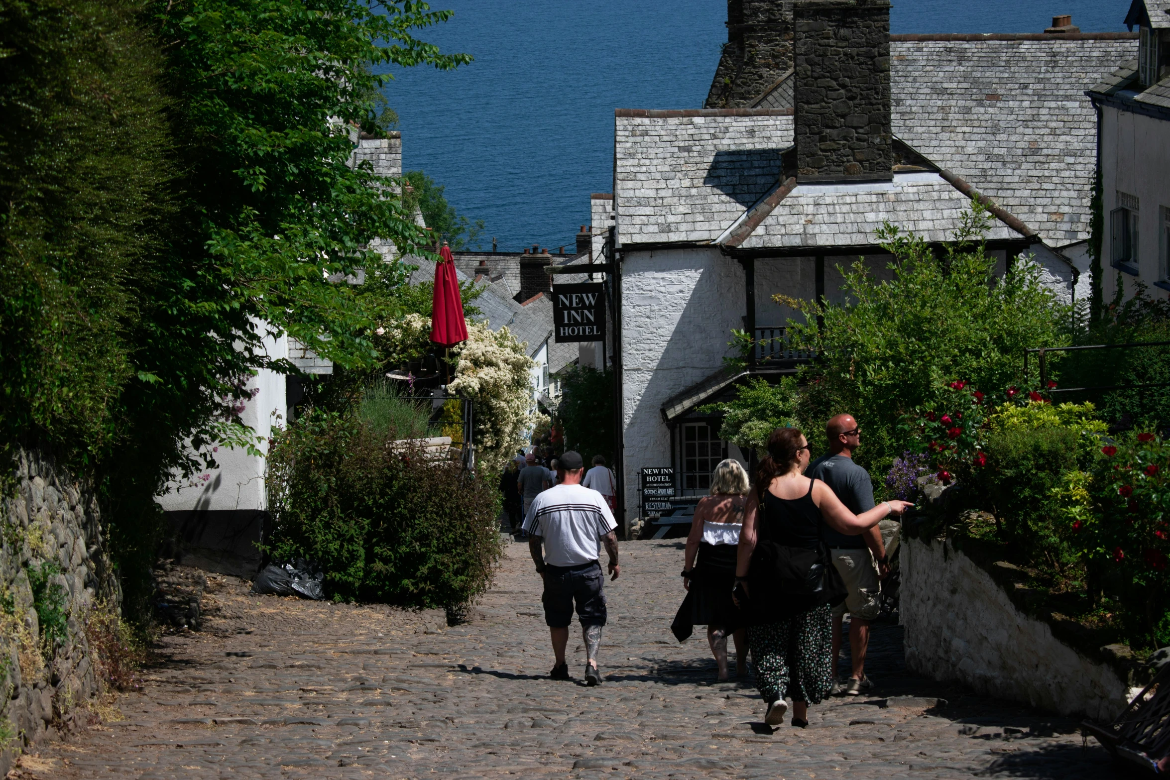 a group of people walk down the narrow walkway