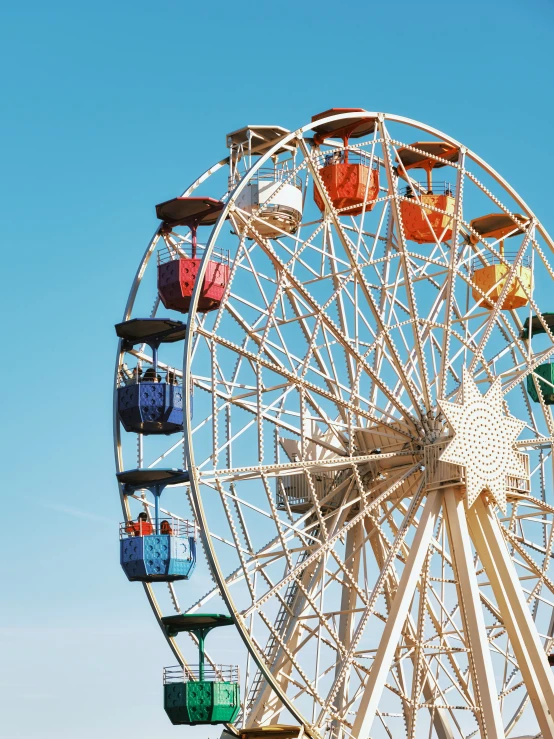 an amut ferris wheel is parked under a bright blue sky