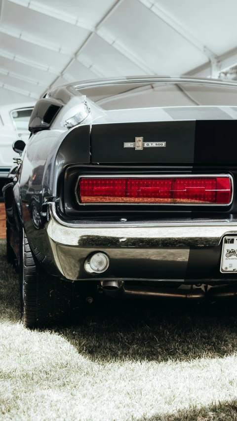 a black mustang parked under a white tent