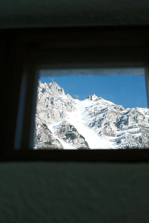 the view out of the window of a snowy mountain range