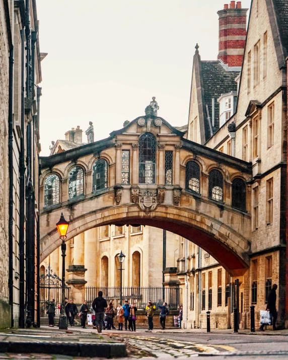 a group of people walk under a bridge in a city