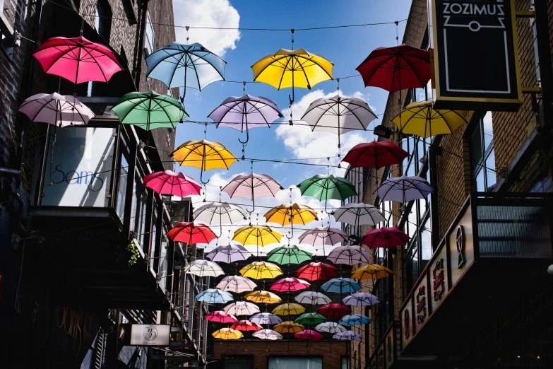 the colorful umbrellas are hung from the wires