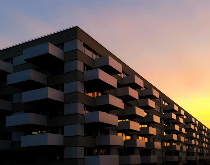 a tall building with balconies at sunset