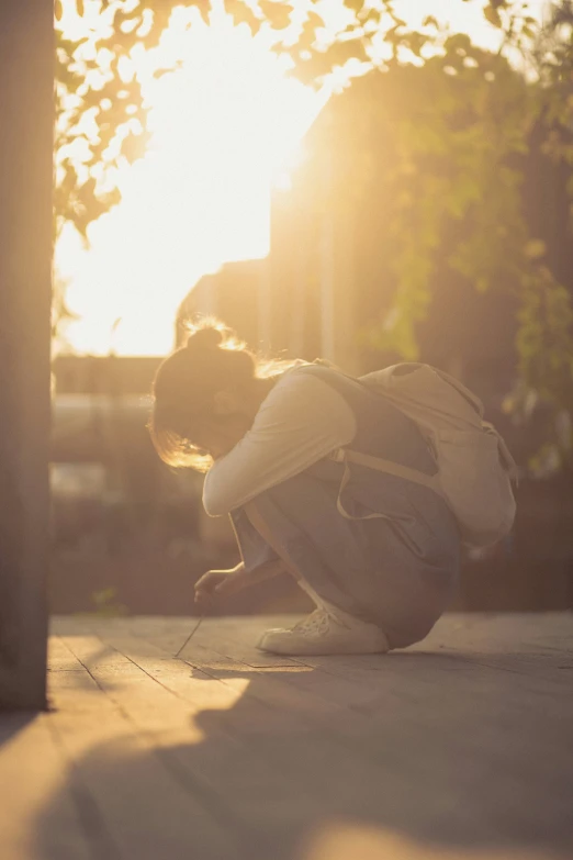 a person sits in the middle of the street at sunset