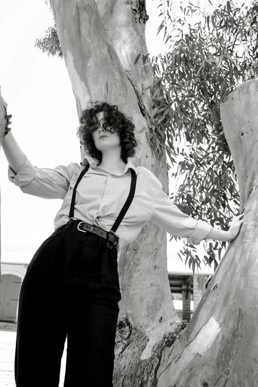 black and white pograph of a woman leaning against a tree