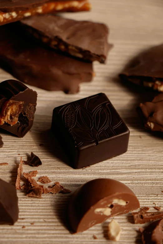 pieces of chocolate on a wood table next to pieces of brittles