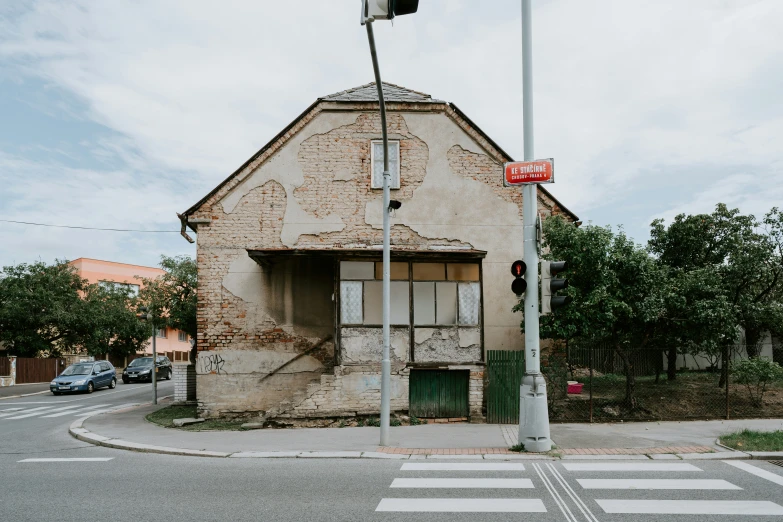 an abandoned building at the intersection with a traffic light