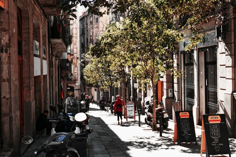 a woman walks down an alley with an old motorcycle parked beside her