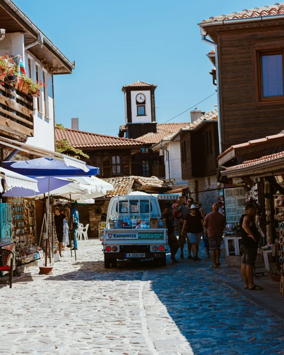 an old fashioned bus driving down a cobblestone street