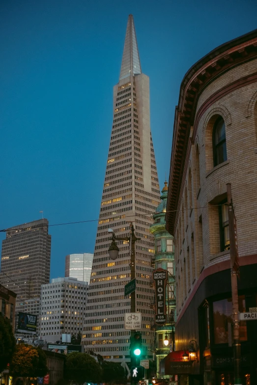 tall buildings and cars on the street near a traffic light