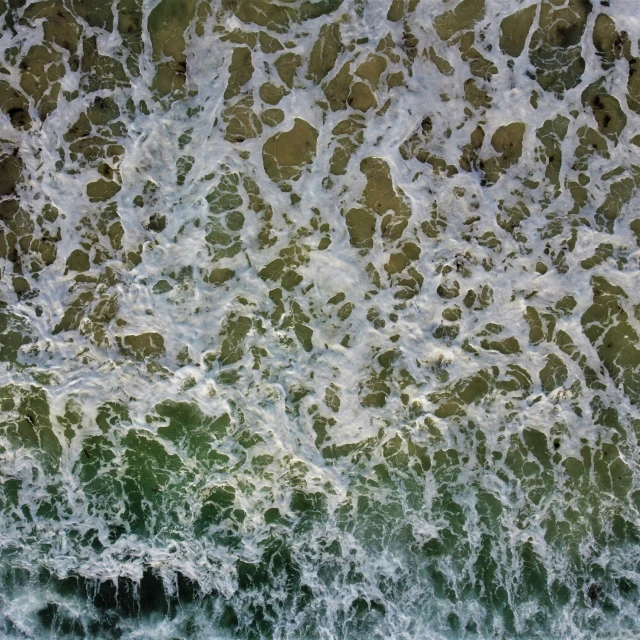 water over a sandy beach with waves crashing in