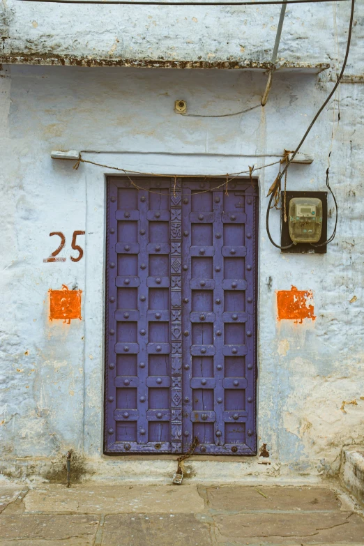 blue door sitting against the side of a building with number 25