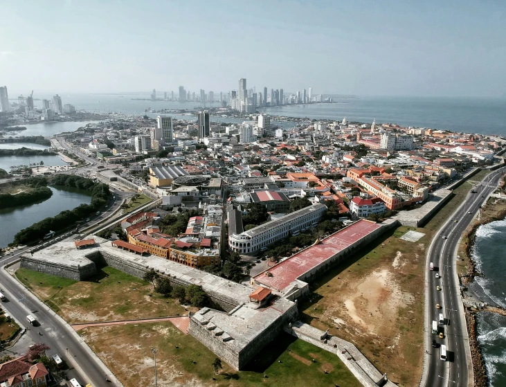 an aerial view of an urban area with sea and high rise buildings