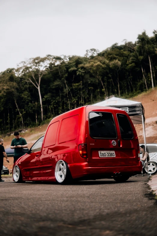 a van sits parked in front of a few men on the side of a hill