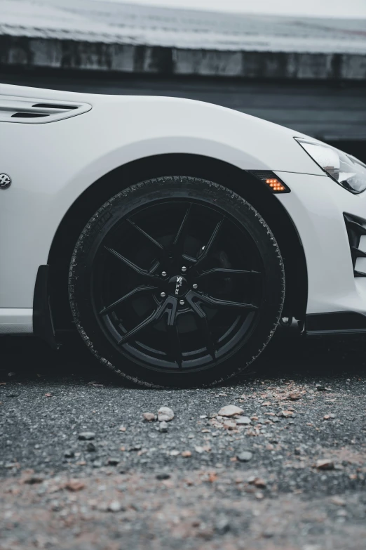 the car is parked on the cement next to the water