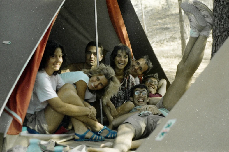 a group of people sit around a tent