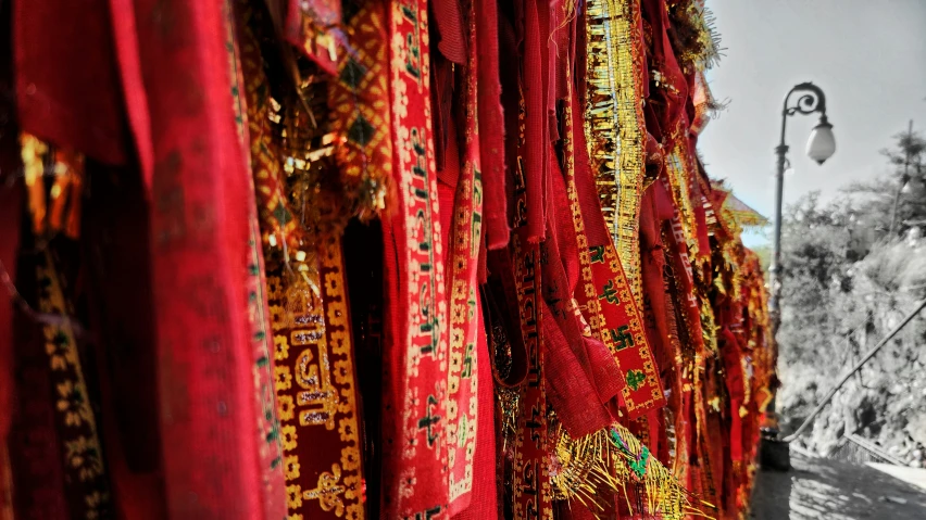 many red cloths hanging on poles near a street lamp