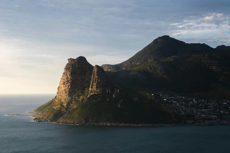 a mountain near water with a sky background