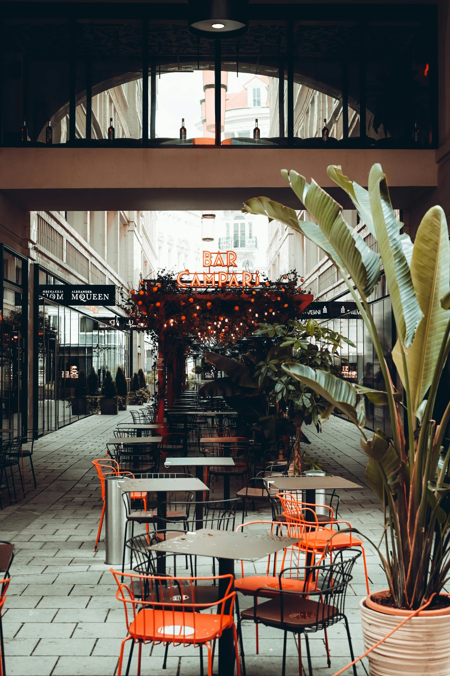 a courtyard with tables and chairs and an umbrella