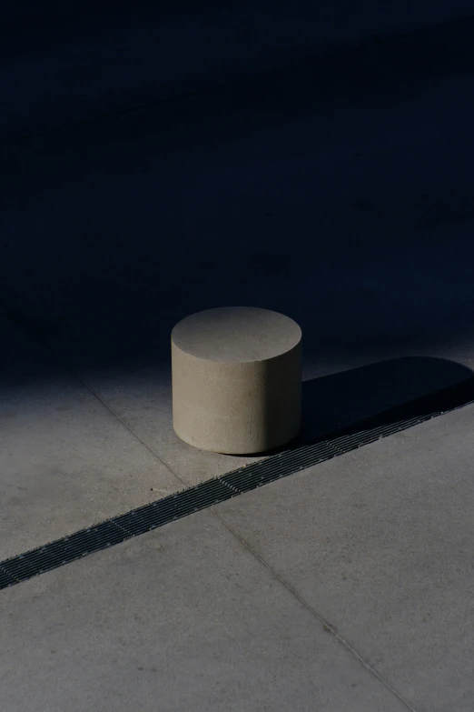 a concrete table casts a shadow on the pavement