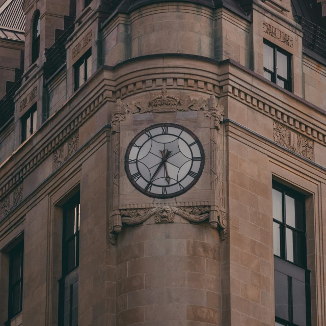 an ornately designed clock on the side of a stone building