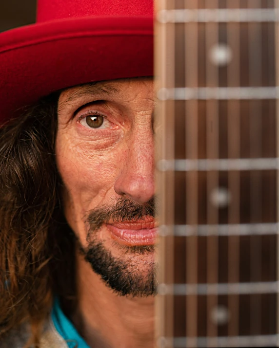 a man with a red hat on playing an acoustic guitar