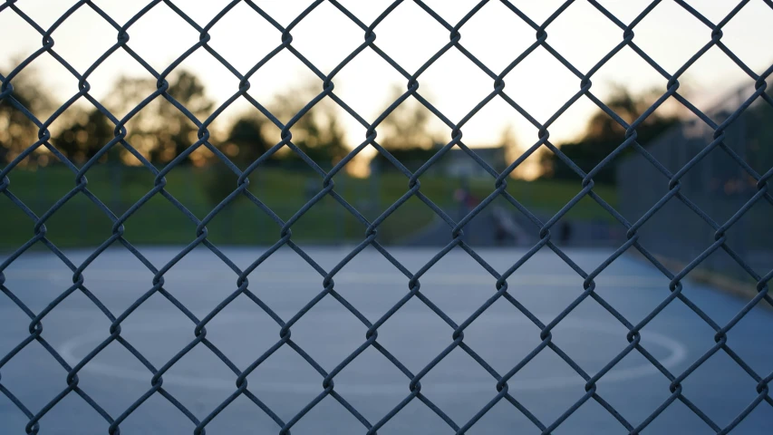 the view through a fence at an outdoor basketball court