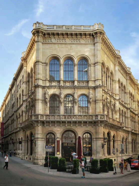 people on a cobblestone street and an old building