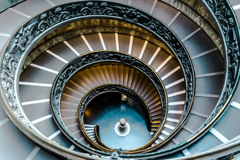 a spiral stair case with the top part in gold