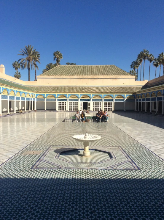 some people sitting on benches around a fountain