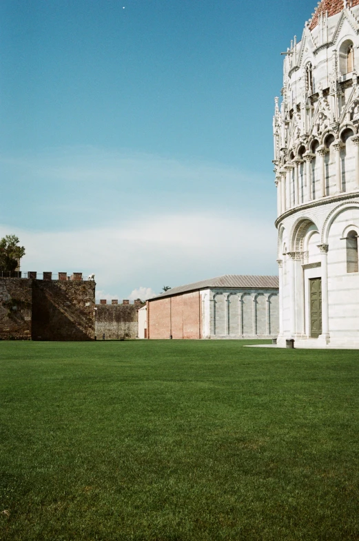 a tall building sitting on top of a lush green field