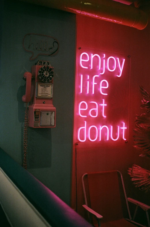 a neon sign that reads enjoy life eat donut