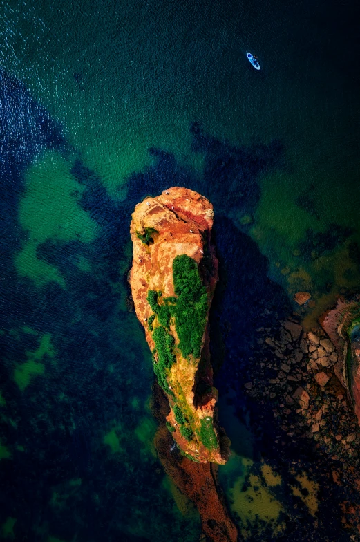 a picture of a rock outcropping in the middle of a body of water