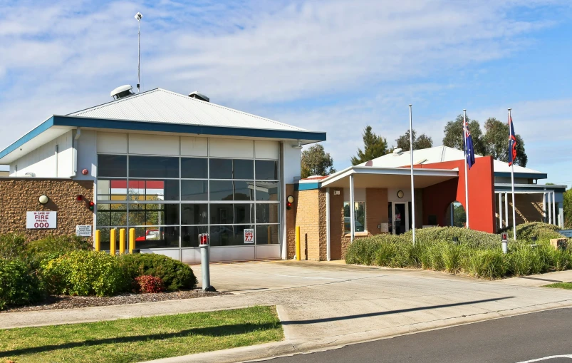 a building with flags outside on top and bushes